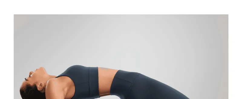 Shows the model wearing the leggings in a relaxed yoga pose to help shoppers envision comfort and mobility.