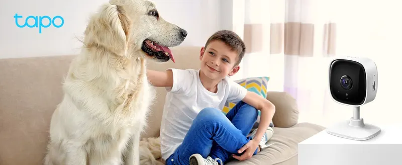 Shows the indoor camera in a warm home setting with family and pet to help shoppers envision home monitoring.